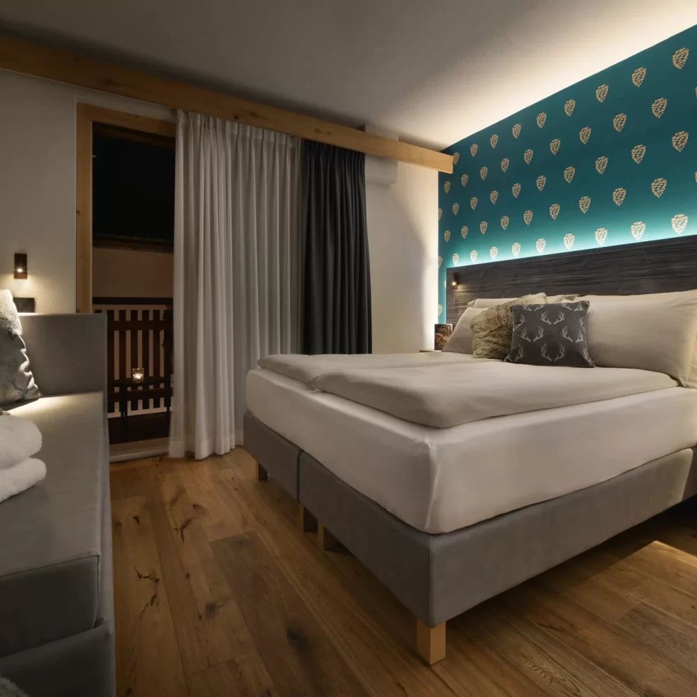 Moderna camera da letto accogliente con pareti decorate e letti in legno su pavimento di parquet.