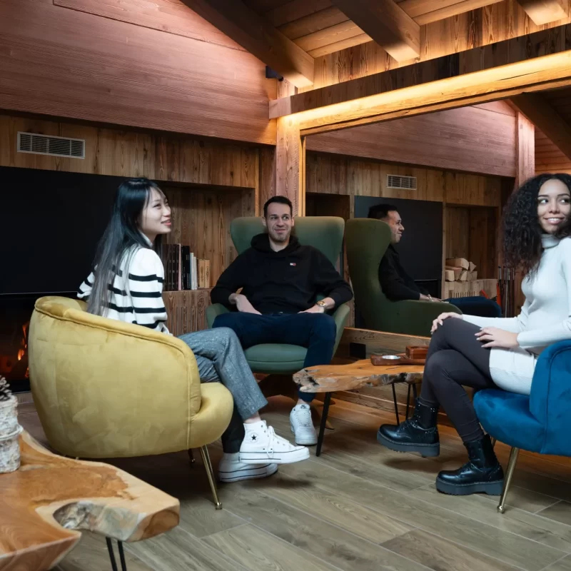 Tre persone sedute in un'accogliente sala con camino acceso.