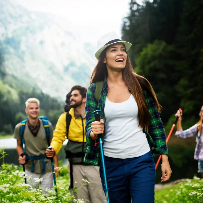Un gruppo di persone felici sta facendo un'escursione in montagna circondato dalla natura.