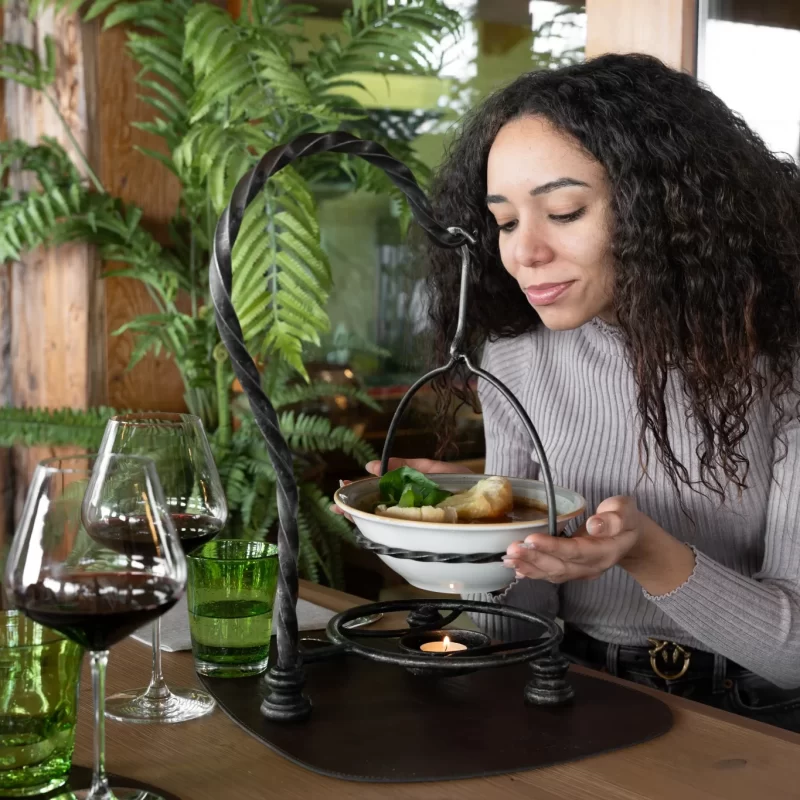 Donna che gusta un piatto di cibo caldo in un ristorante elegante.