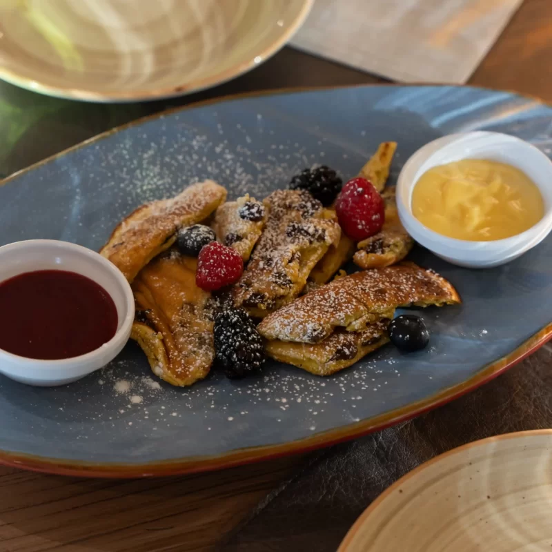 Piatto di Kaiserschmarrn con frutti di bosco e salse.